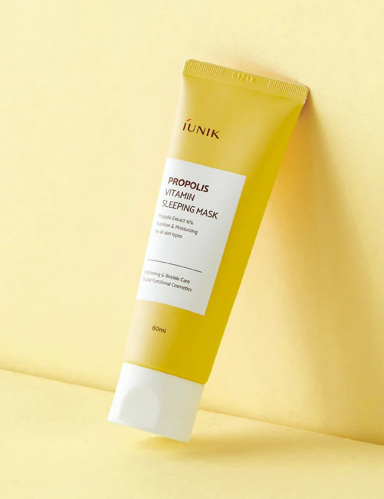 A yellow tube of iUNIK Propolis Vitamin Sleeping Mask against a soft yellow background, promoting hydration and nourishment for all skin types.