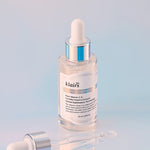 Klairs Freshly Juiced Vitamin Drop in a transparent serum bottle with a dropper, set against a soft pastel gradient background, emphasizing its brightening formula.