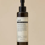 Dark bottle of Klairs Gentle Black Deep Cleansing Oil on a textured stone surface, featuring a pump top and product label, showcasing its deep cleansing properties.