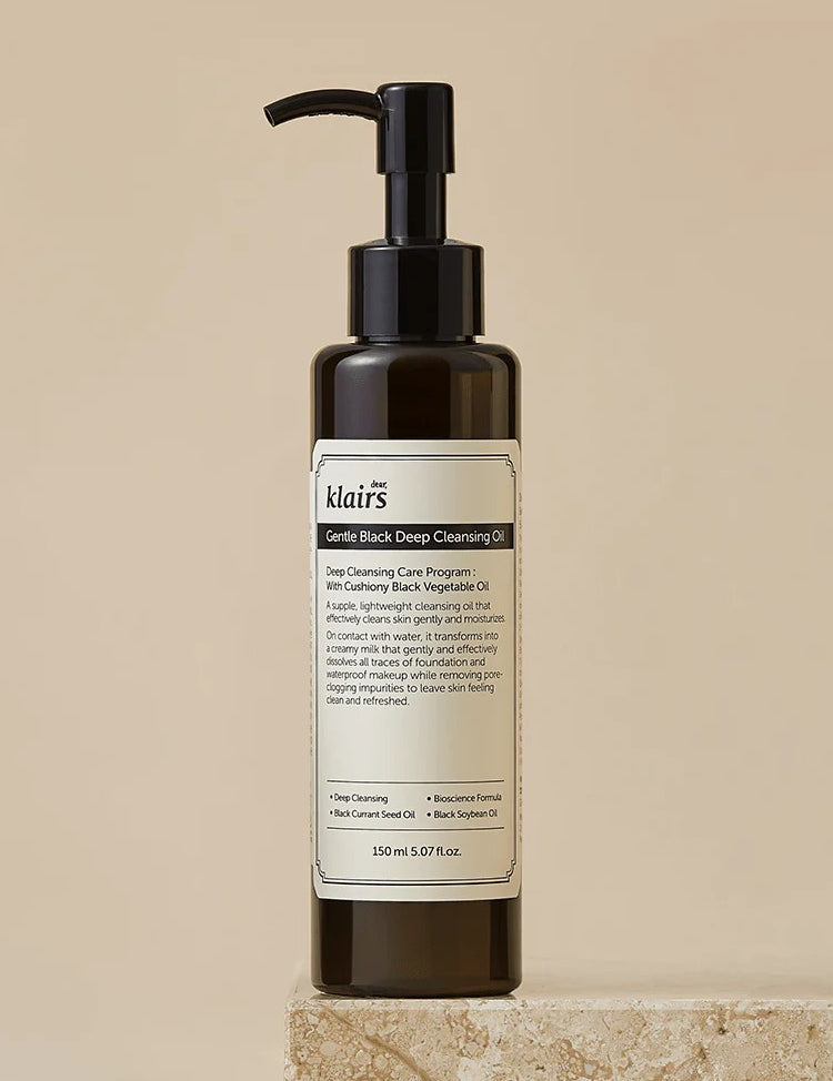 Dark bottle of Klairs Gentle Black Deep Cleansing Oil on a textured stone surface, featuring a pump top and product label, showcasing its deep cleansing properties.