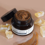 Klairs Gentle Black Sugar Facial Polish jar open to display its rich brown exfoliating scrub, surrounded by sugar crystals on a smooth, light surface, emphasizing its gentle exfoliation.