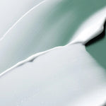 Close-up of smooth, creamy white samples of the Laneige Cica Sleeping Mask on a soft green backdrop.