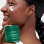 A model with sleek hair holding a green jar of Laneige Cica Sleeping Mask against her shoulder, highlighting skin hydration and barrier support.