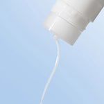 Close-up of Laneige Cream Skin Cerapeptide™ Refiner pouring its milky, lightweight liquid against a soft blue background.