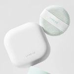 A white, square compact and mint green puff from Laneige Neo Essential Blurring Finish Powder displayed against a soft gray background.