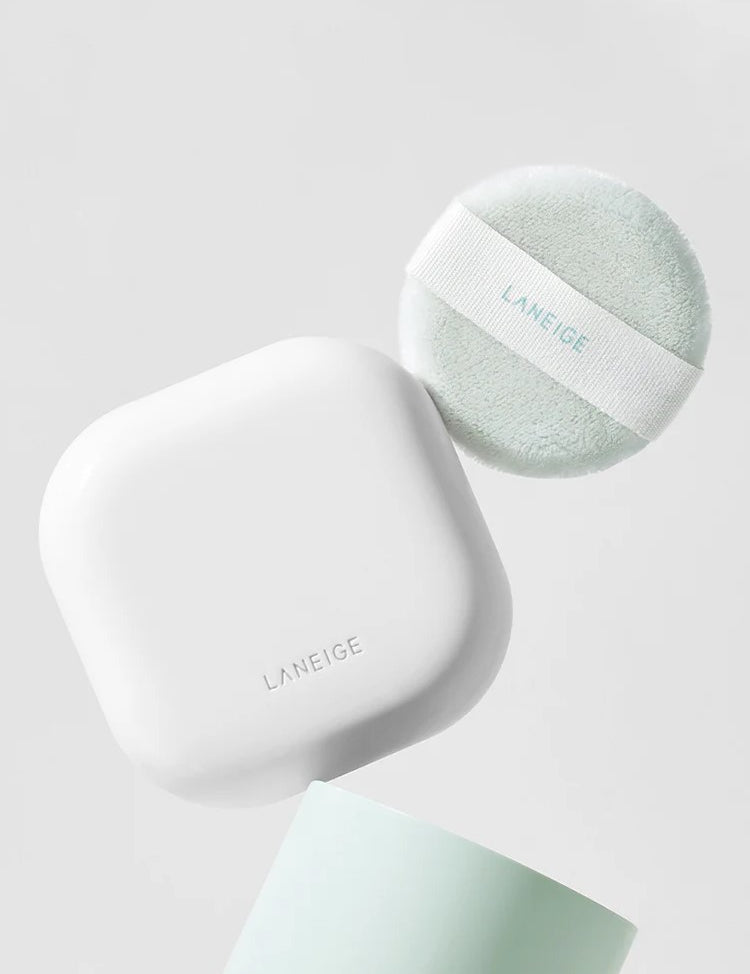 A white, square compact and mint green puff from Laneige Neo Essential Blurring Finish Powder displayed against a soft gray background.