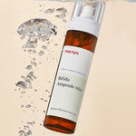 Bottle of Manyo Bifida Ampoule Mist floating in water with droplets, emphasizing its barrier-strengthening and hydrating benefits.