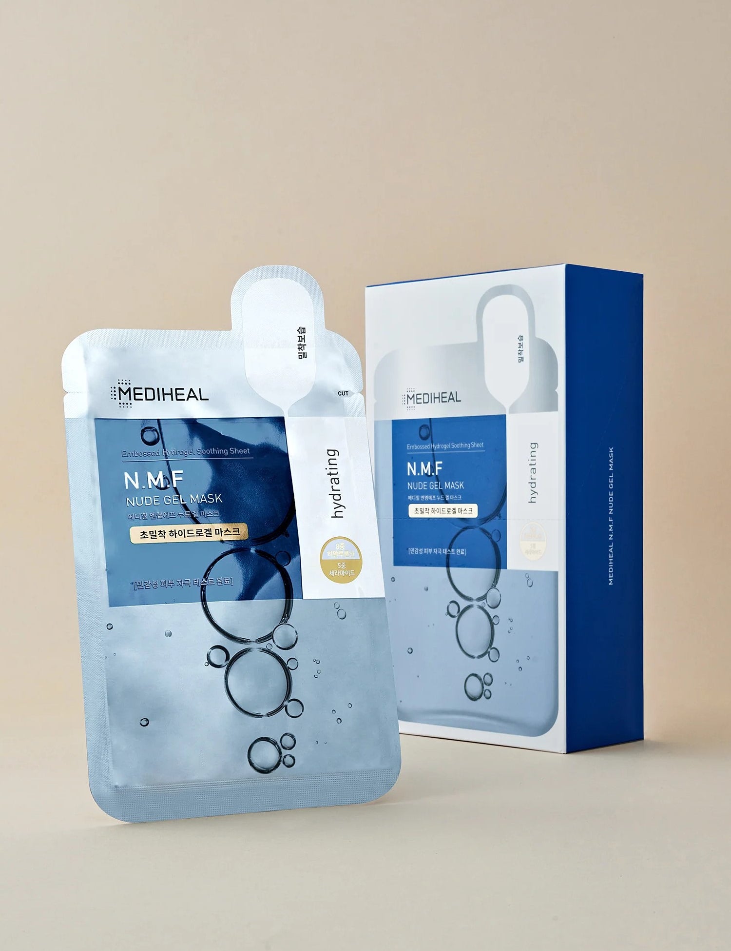 A Mediheal N.M.F. Nude Gel Mask package and sheet, featuring blue bubbles on its design, set against a soft beige background.