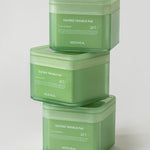 Three stacked green jars of Mediheal Teatree Trouble Pad, designed for day and night use, set against a light gray background.