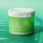 Green jar labeled 'Neogen Dermalogy Green Tea Moist PHA Gauze Peeling' displayed against a vibrant green background with soft shadows, highlighting its exfoliating and hydrating properties.
