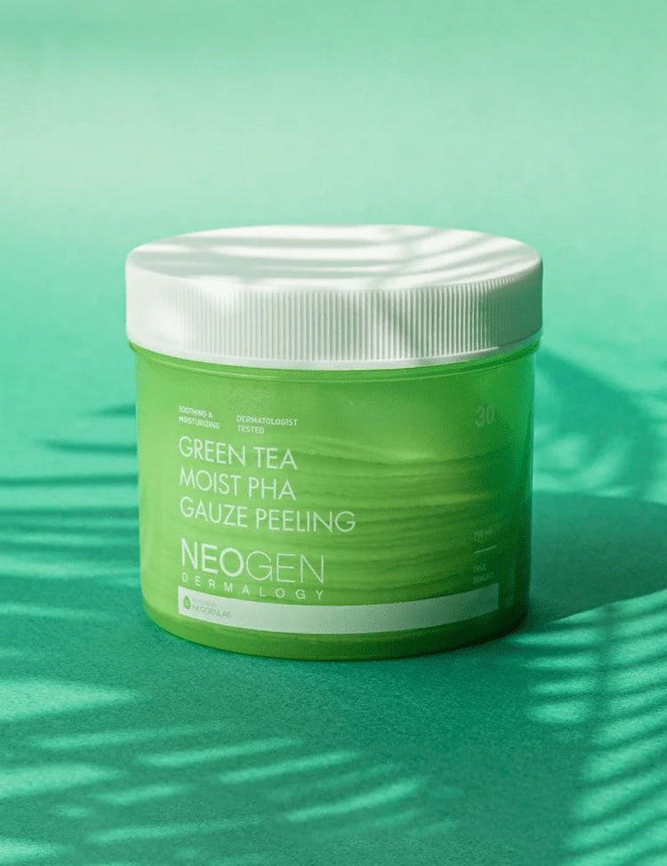 Green jar labeled 'Neogen Dermalogy Green Tea Moist PHA Gauze Peeling' displayed against a vibrant green background with soft shadows, highlighting its exfoliating and hydrating properties.