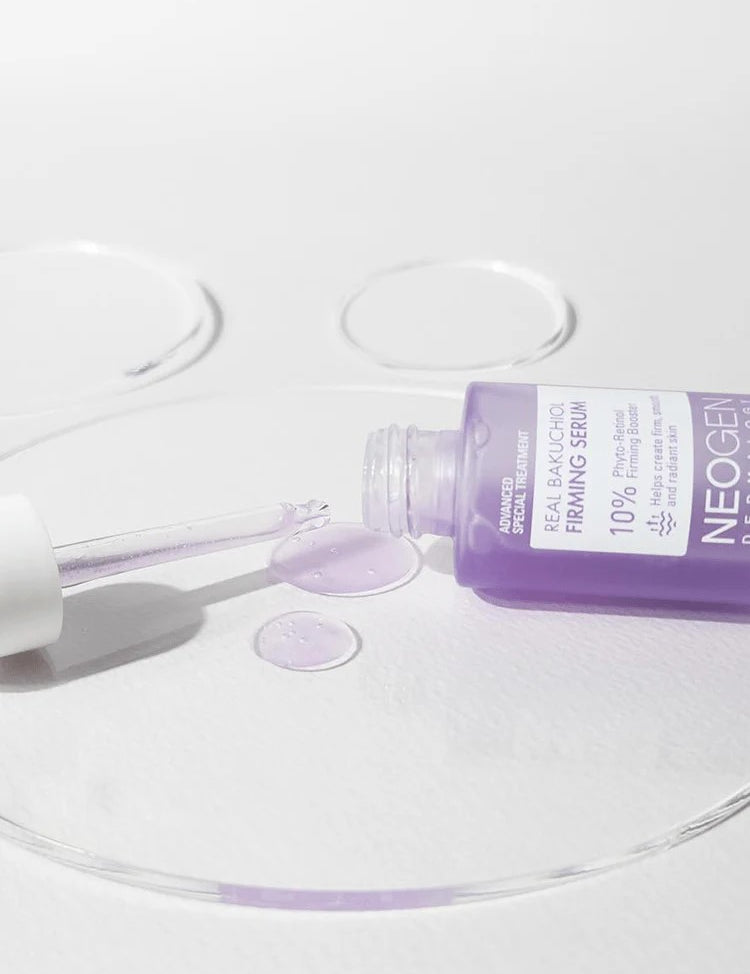 Neogen Bakuchiol Firming Serum bottle with a dropper, spilling vibrant purple liquid onto a white surface, emphasizing its lightweight texture and firming benefits.