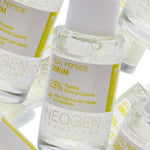 Close-up of Neogen Real Peptide Serum bottles containing clear liquid, featuring a yellow label highlighting 2.5% peptide for firming benefits.