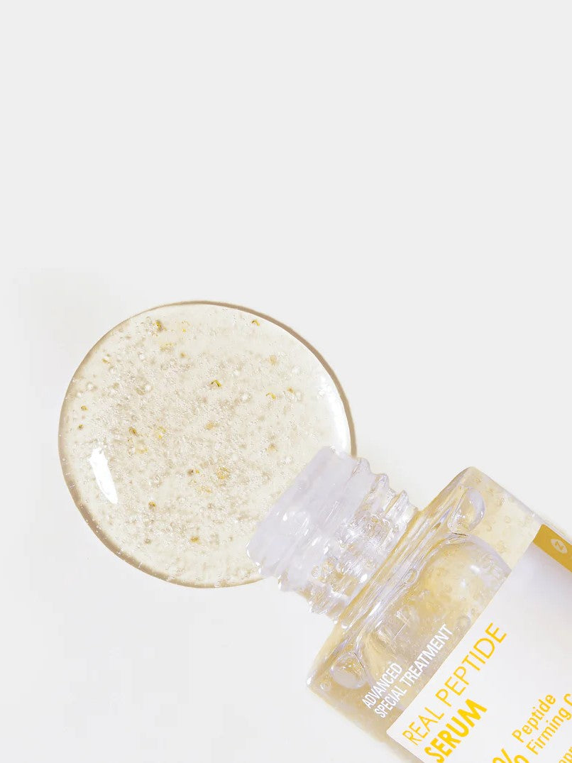 Close-up of a clear serum with golden Peptide beads alongside its transparent bottle labeled 'Neogen Real Peptide Serum,' displayed on a white background.