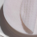 Close-up of white cotton rounds stacked together, highlighting the 100% natural viscose fabric texture of Papa Recipe Eggplant Clearing Peeling Pads.