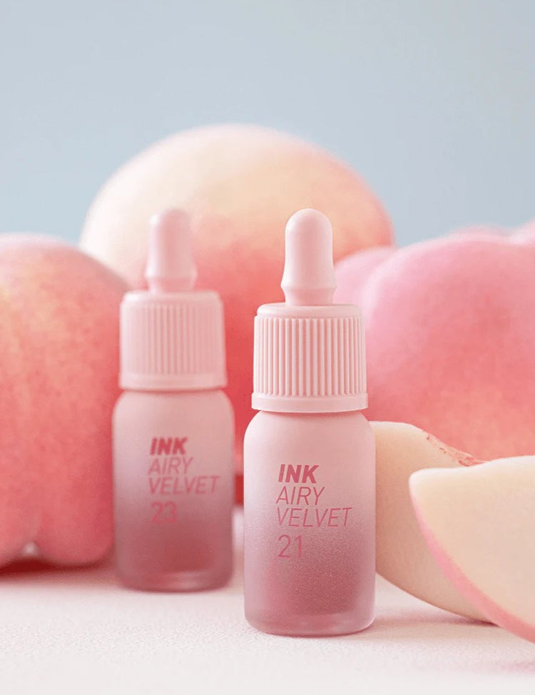 Peripera INK AIRY VELVET 21 and 23 Peaches Collection lip tints displayed amidst soft peach-like backgrounds and slices.