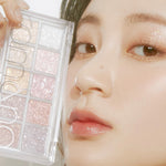 A model holds the glittery Romand Better Than Palette Light and Glitter Garden eyeshadow palette, showing the shimmering shades applied on her eyes.