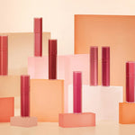 A colorful display of multiple Romand Blur Fudge Tint shades, arranged on geometric blocks.