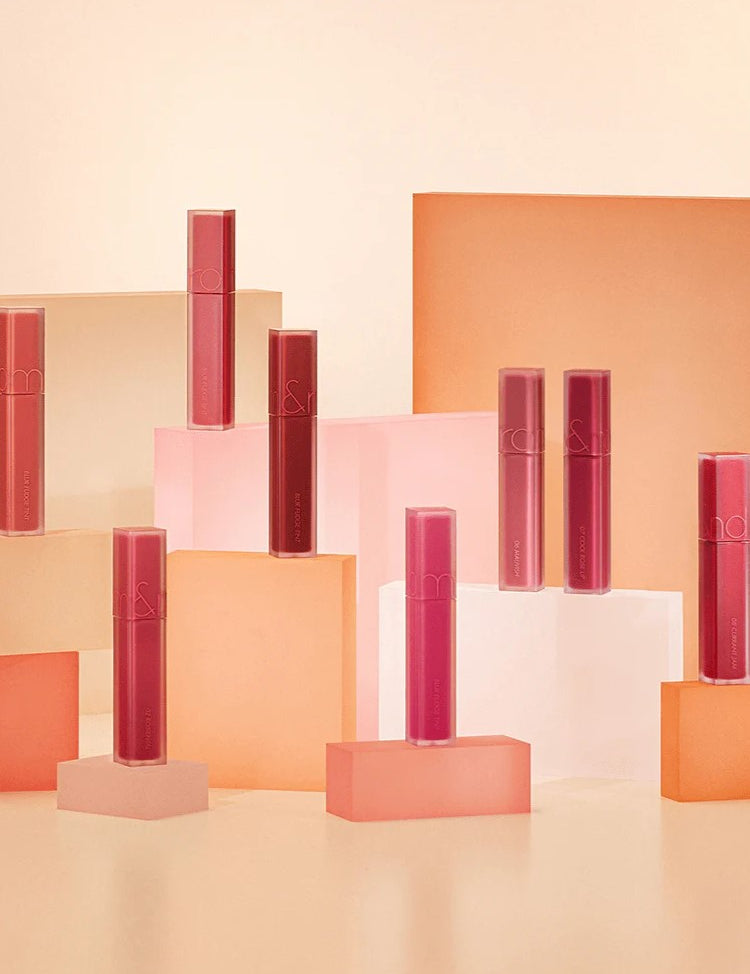 A colorful display of multiple Romand Blur Fudge Tint shades, arranged on geometric blocks.