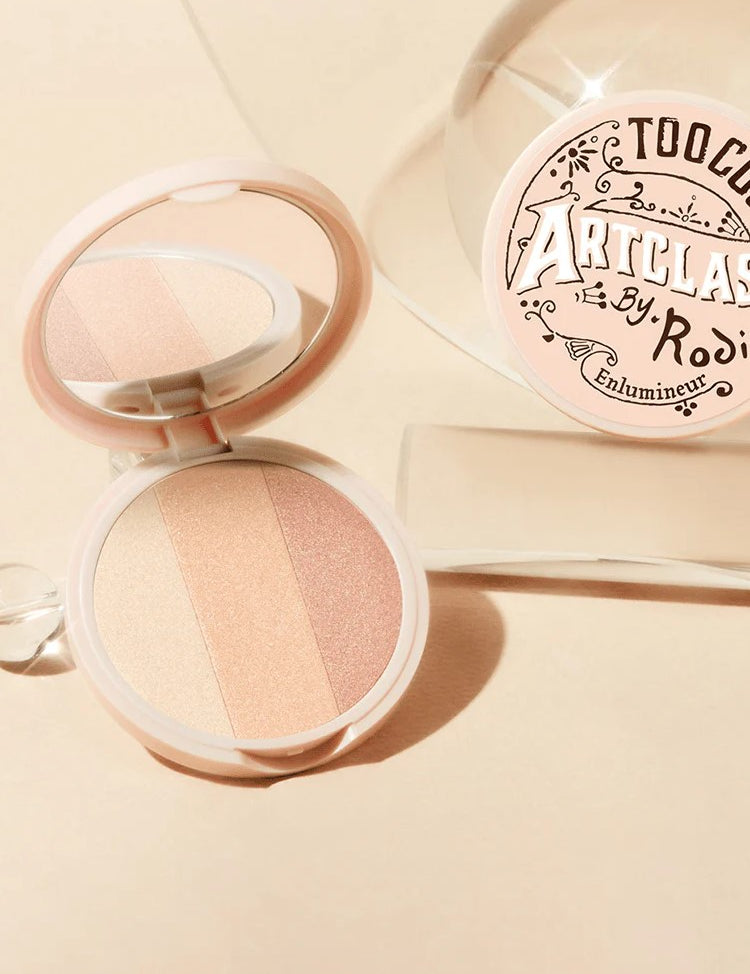Too Cool for School Artclass By Rodin Highlighter #1 Glam, with three shimmering shades, sits open beside its decorative packaging, showcasing a pink and beige color palette.
