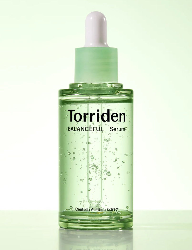 Green glass dropper bottle of Torriden's Balanceful Serum with visible bubbles, highlighting 'Centella Asiatica Extract' as a key ingredient on the label.