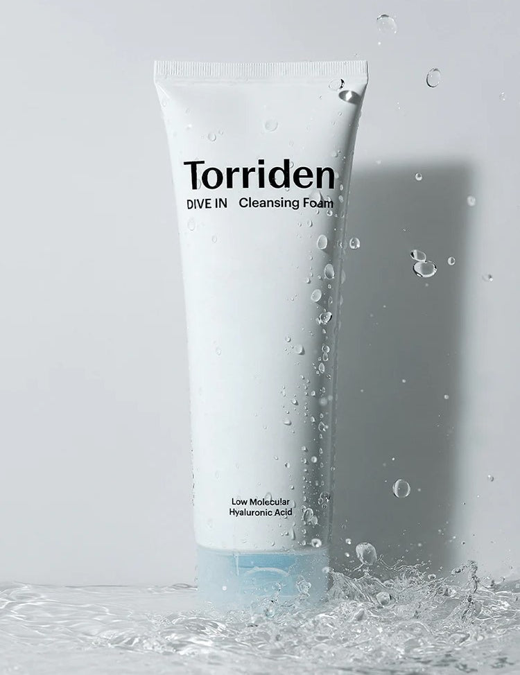 White tube of Torriden DIVE IN Cleansing Foam with water droplets, labeled 'Low Molecular Hyaluronic Acid.