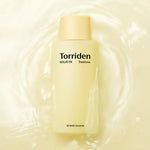 Yellow bottle of Torriden Solid IN Essence with light yellow cap, surrounded by water, highlighting its 5D Multi Ceramide formula.